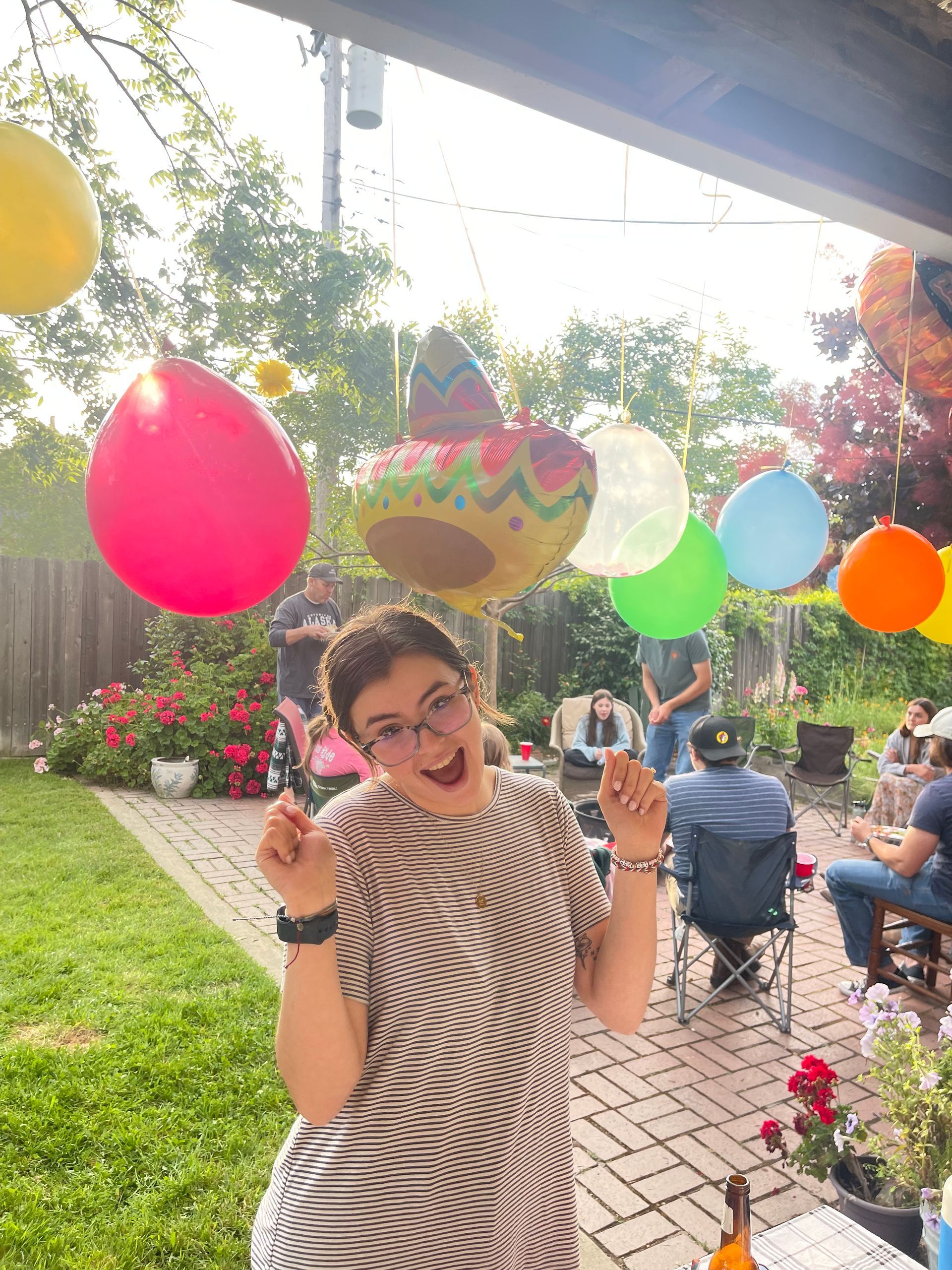 A woman is holding a balloon in front of a group of people.