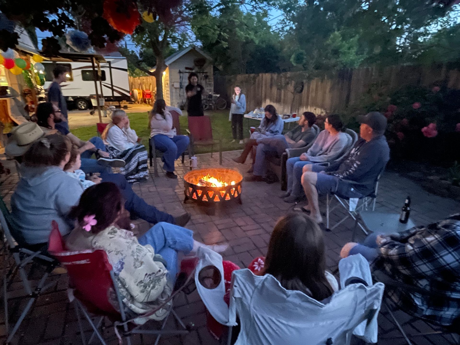 A group of people are sitting around a fire pit.