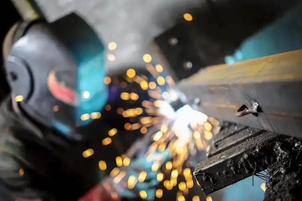 A Man Wearing A Welding Helmet Is Welding A Piece Of Metal — Agriweld Engineering in Dubbo, NSW