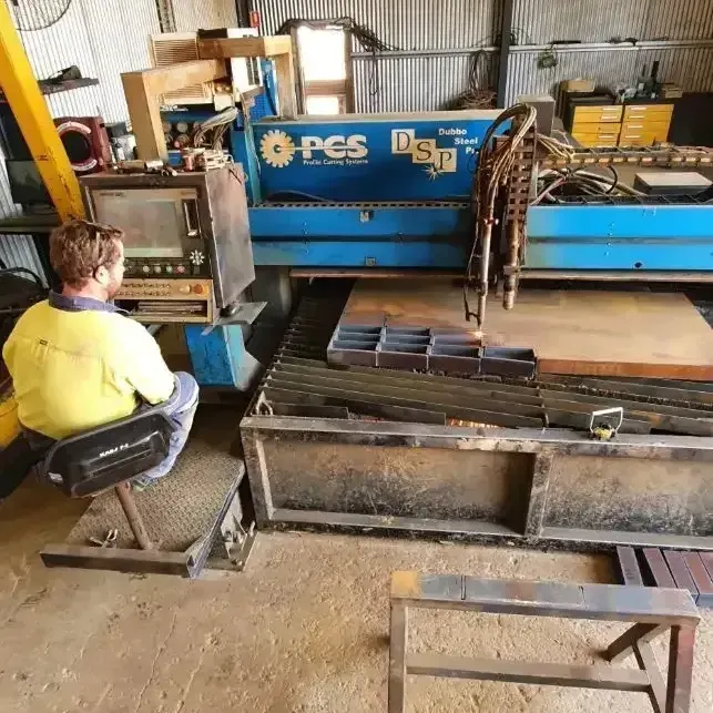 A Man Is Sitting In Front Of A Machine That Says PCS On It — Agriweld Engineering in Dubbo, NSW