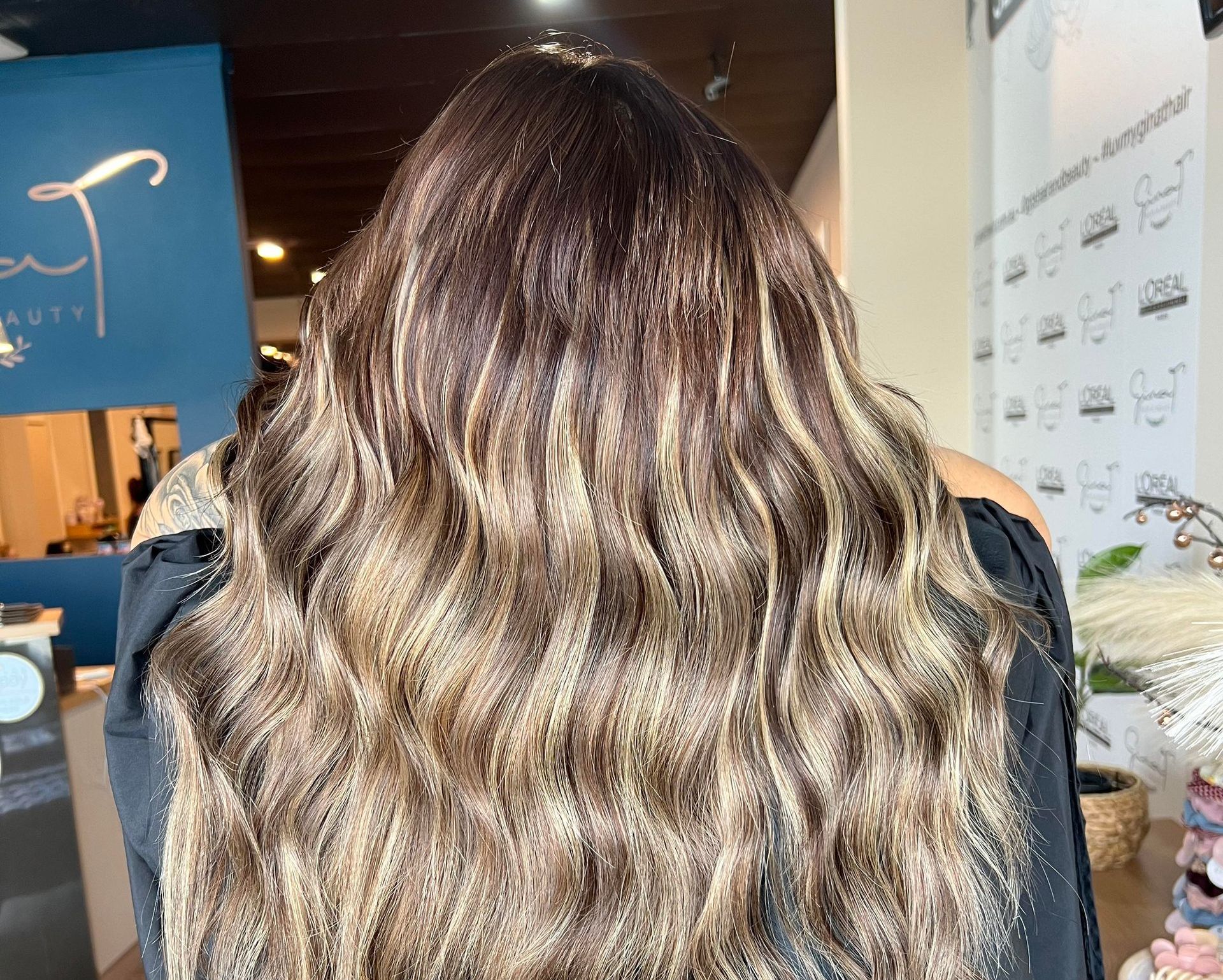 Woman With Long, Wavy, Brown and Blonde Highlighted Hair — Gina T Hair & Beauty In Mackay, QLD