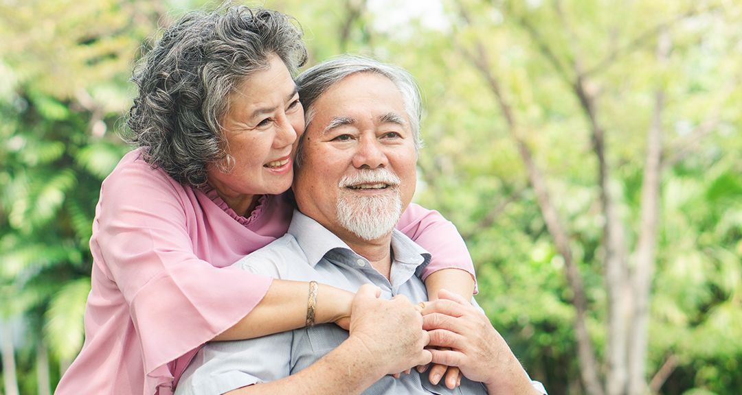 woman hugging a man from behind lovingly