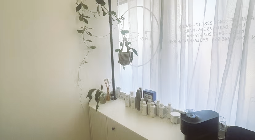 Bright minimalist café interior with pendant lights, shelves, and sunlit curtains