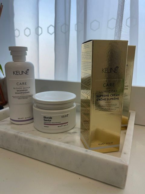 Kérastase haircare products displayed on a marble tray by a window