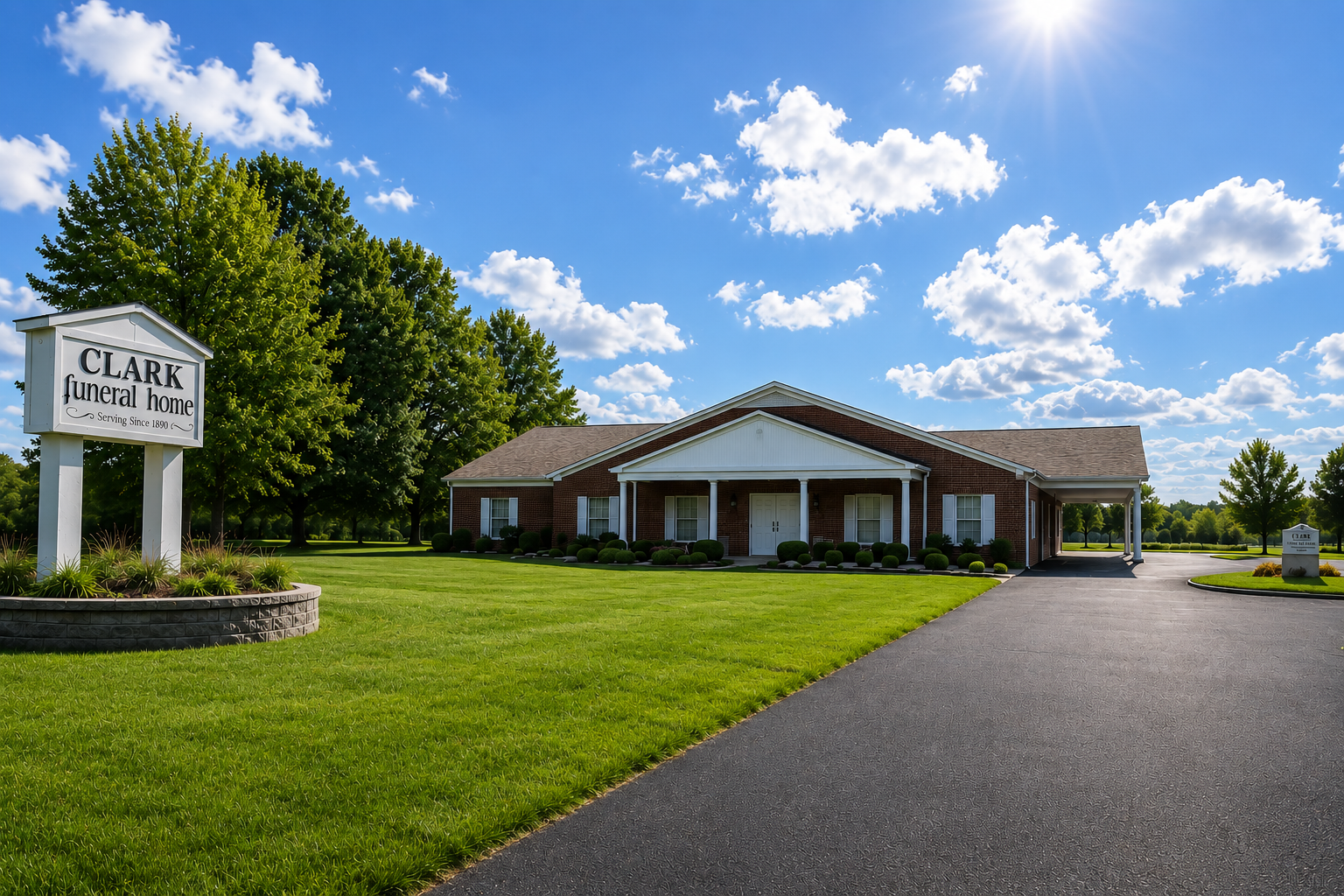 Low-rise brick church building with a sign and covered entrance at sunset