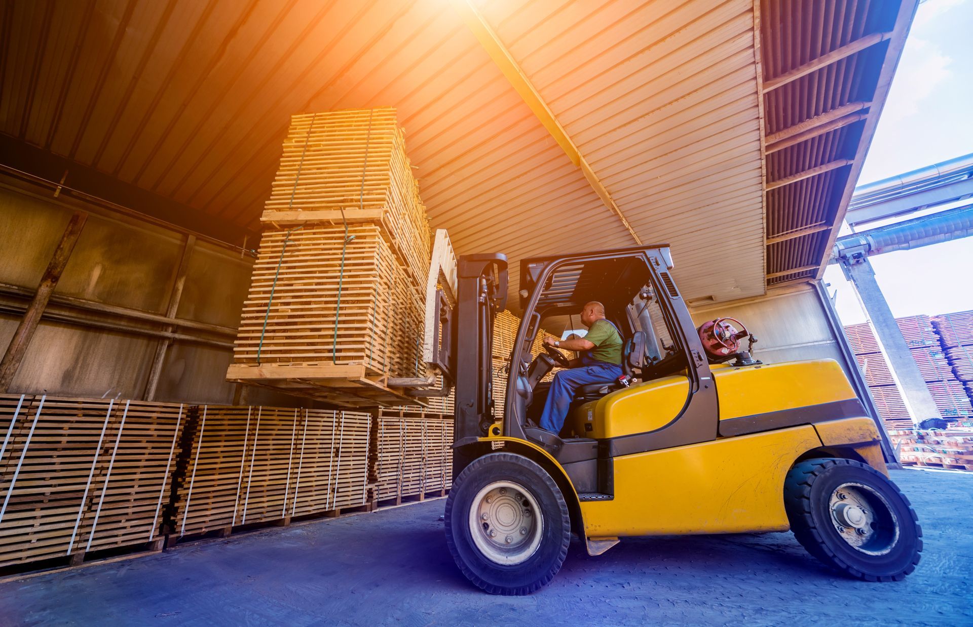 A forklift loader loads lumber into a dry kiln. A forklift loader loads lumber into a dry kiln.