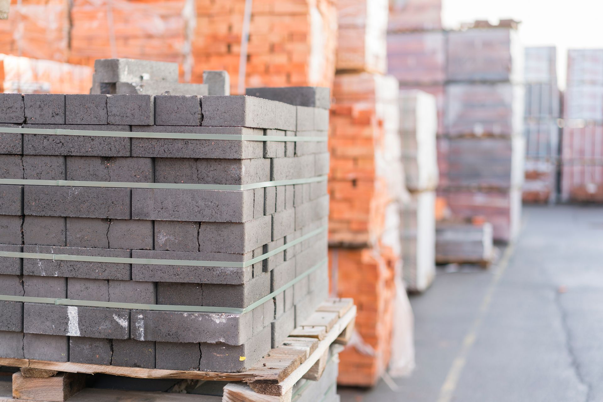 Stacked construction material bricks on pallets at a building site.