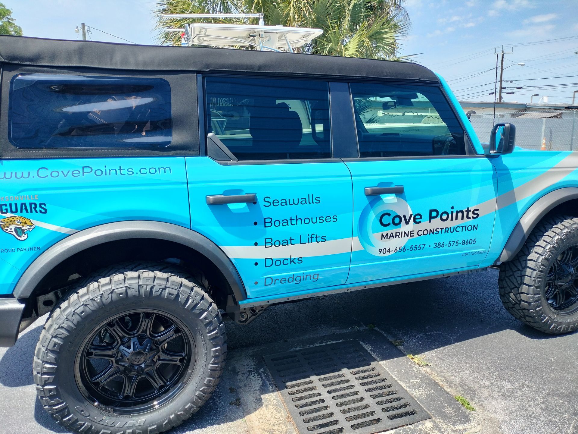 Turquoise Ford Bronco with black wheels and 