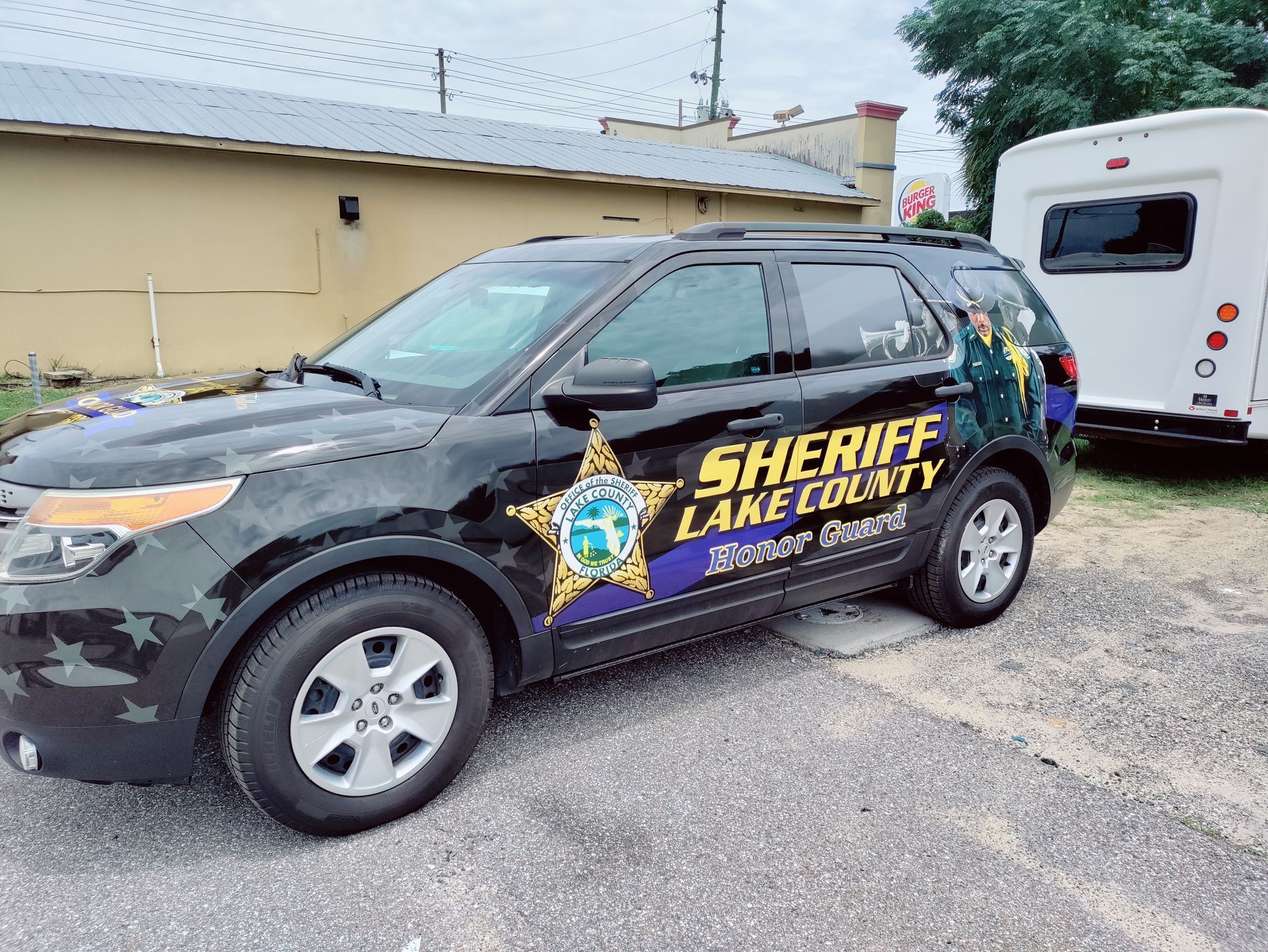 Black Lake County Sheriff SUV parked near a white trailer.