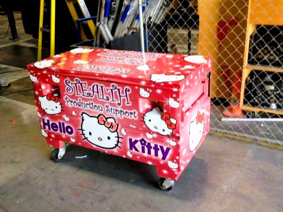 A red Hello Kitty-themed box on wheels with the words 