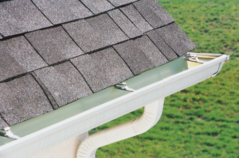 A close up of a gutter on a roof of a house.