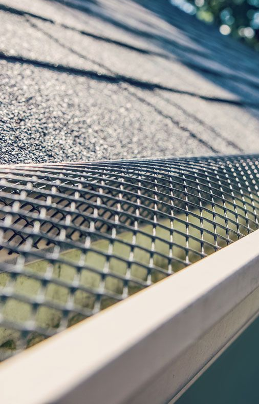 Close-up of a textured metal roof edge with sunlight and shadows