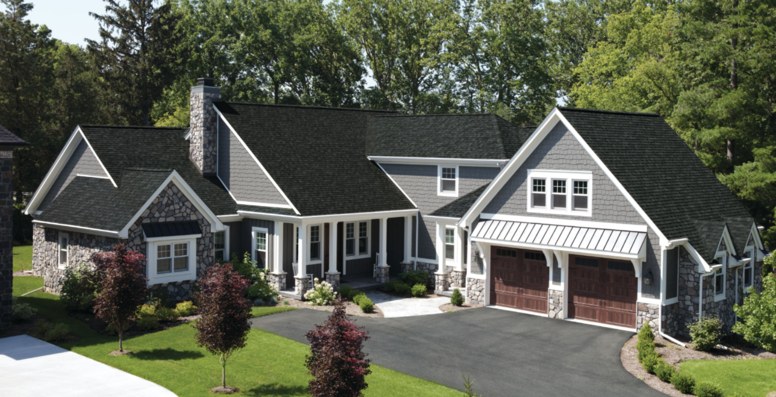 A large white house with a large porch and red shutters.