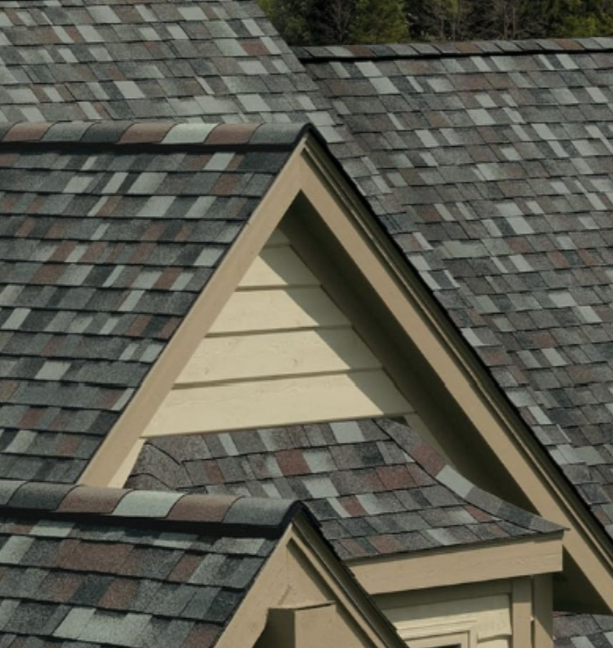 A white house with a gray roof and a brown trim