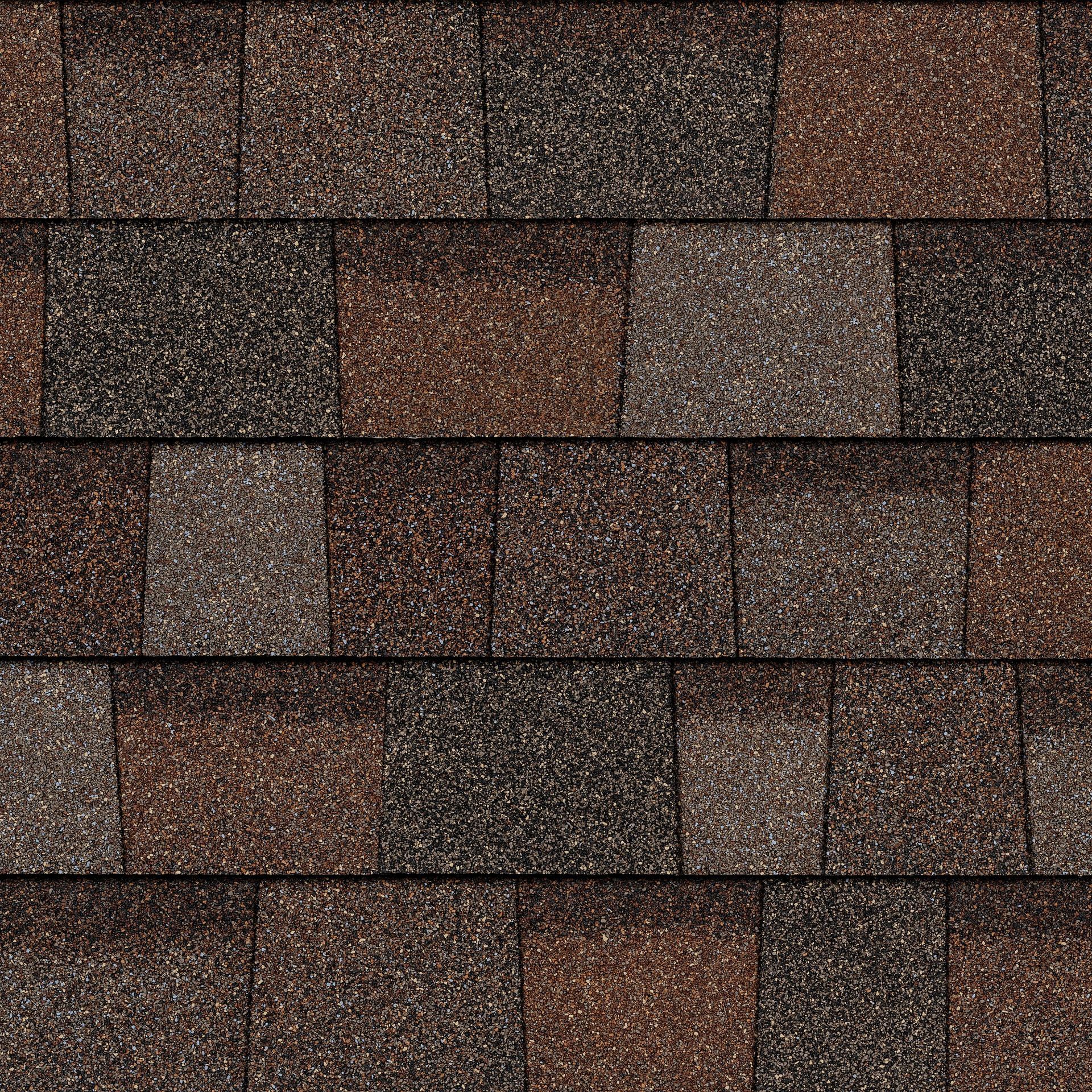 A close up of a row of brown shingles on a roof.