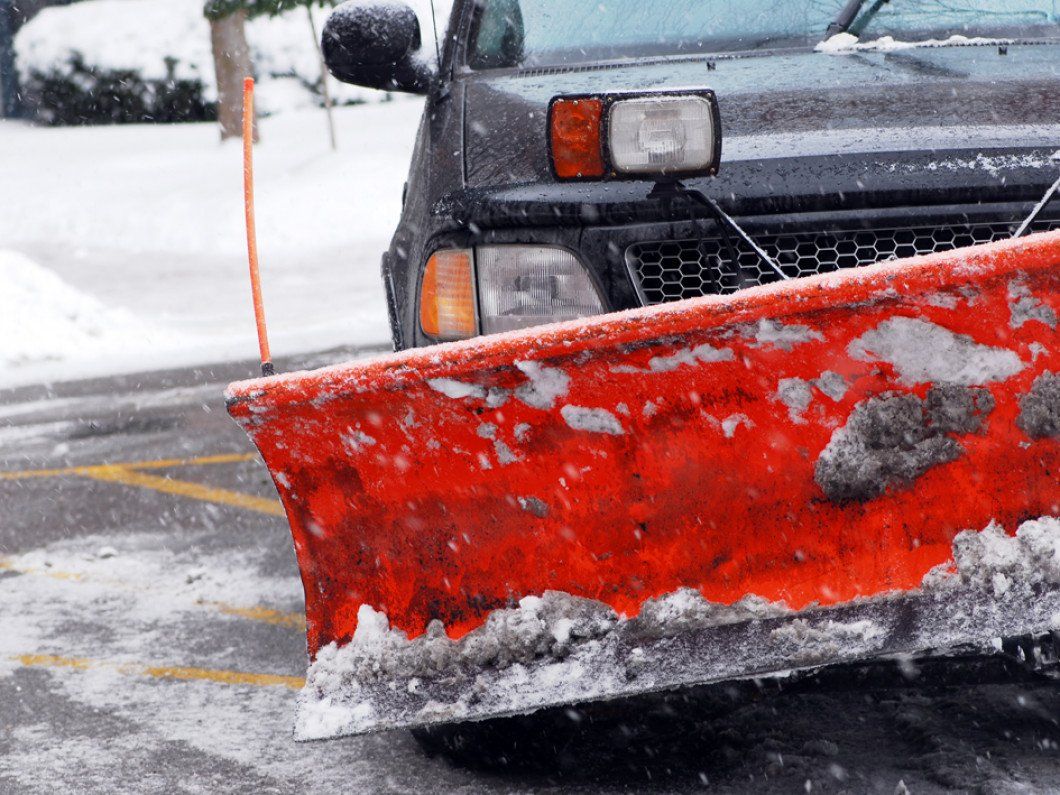 Snow plow truck on a road during a snowstorm