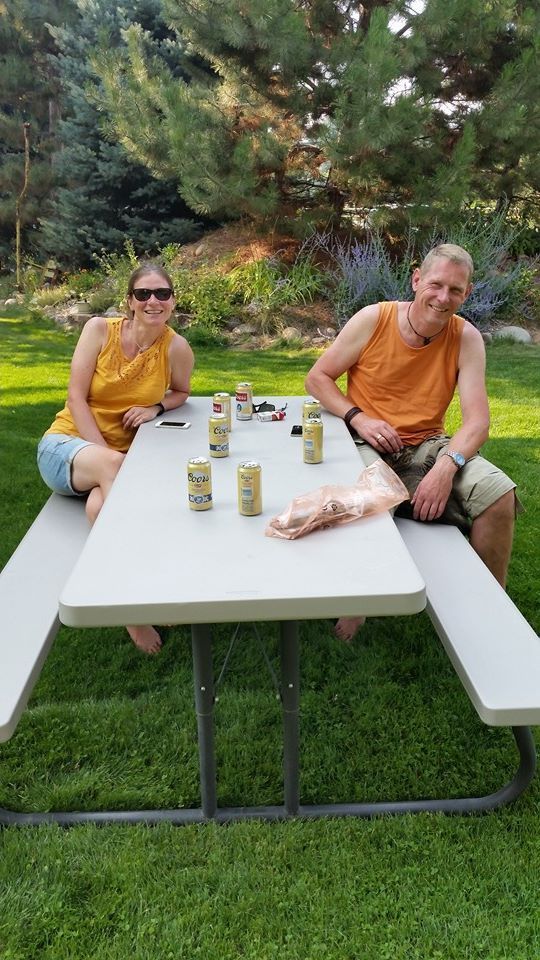 A man and a woman are sitting at a picnic table.