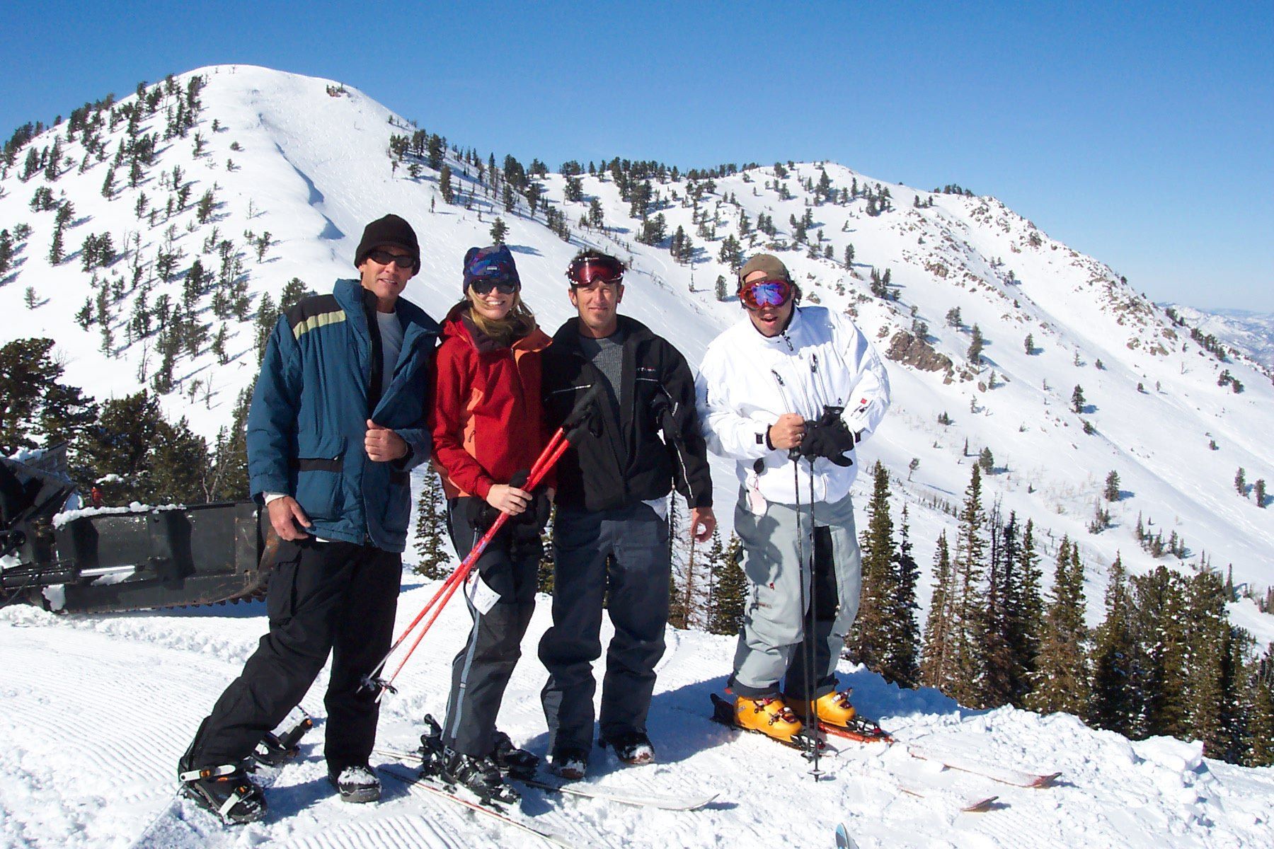 A group of people standing on top of a snow covered mountain