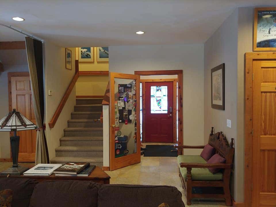 A living room with stairs and a red door