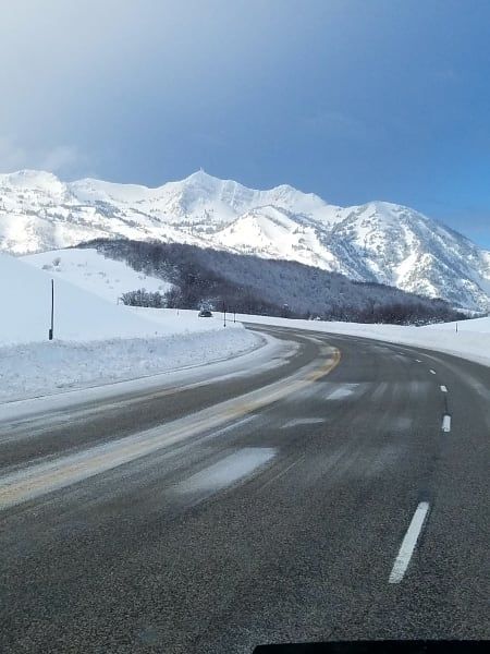 A snowy road with mountains in the background