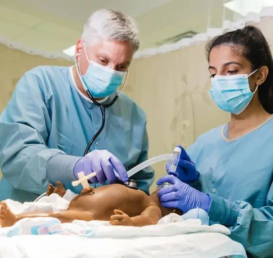 Two medical professionals tending to a newborn baby in a hospital.