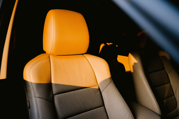 Two-tone car seats with orange headrests and black upholstery in a dark interior