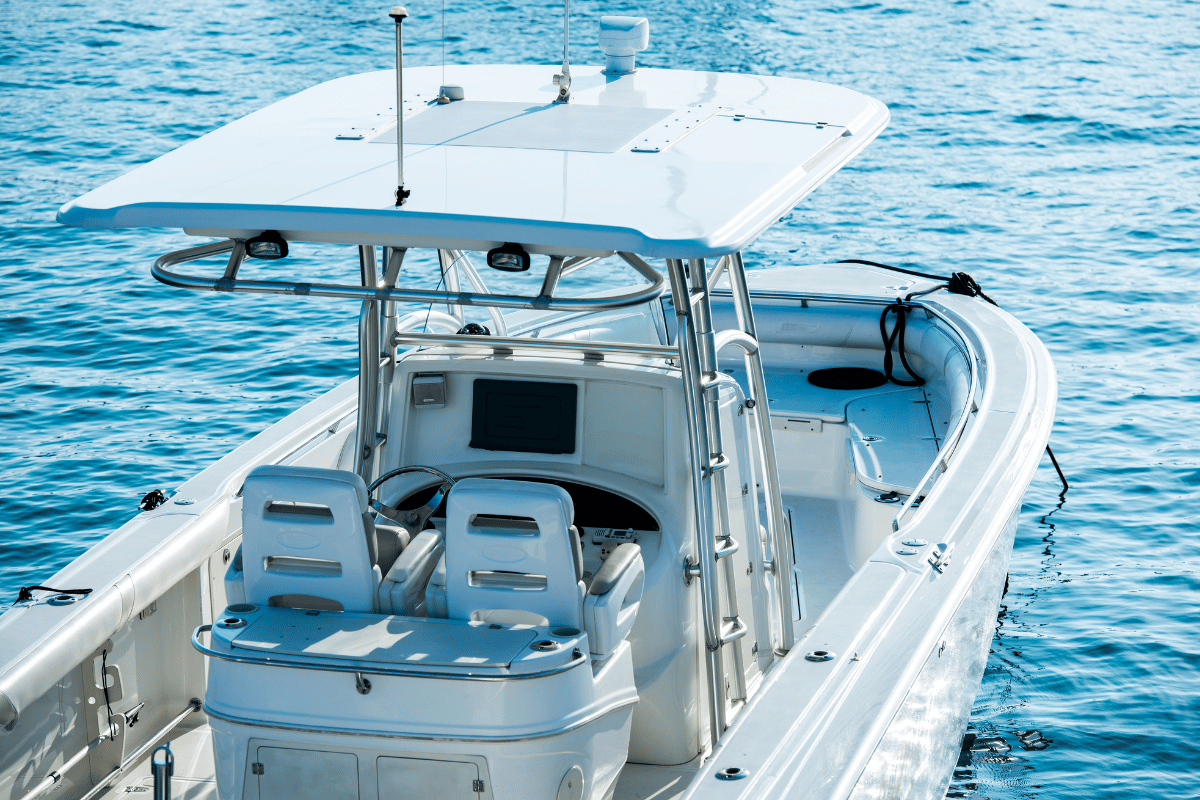 White motorboat cruising on blue water, with a canopy and seating visible on deck