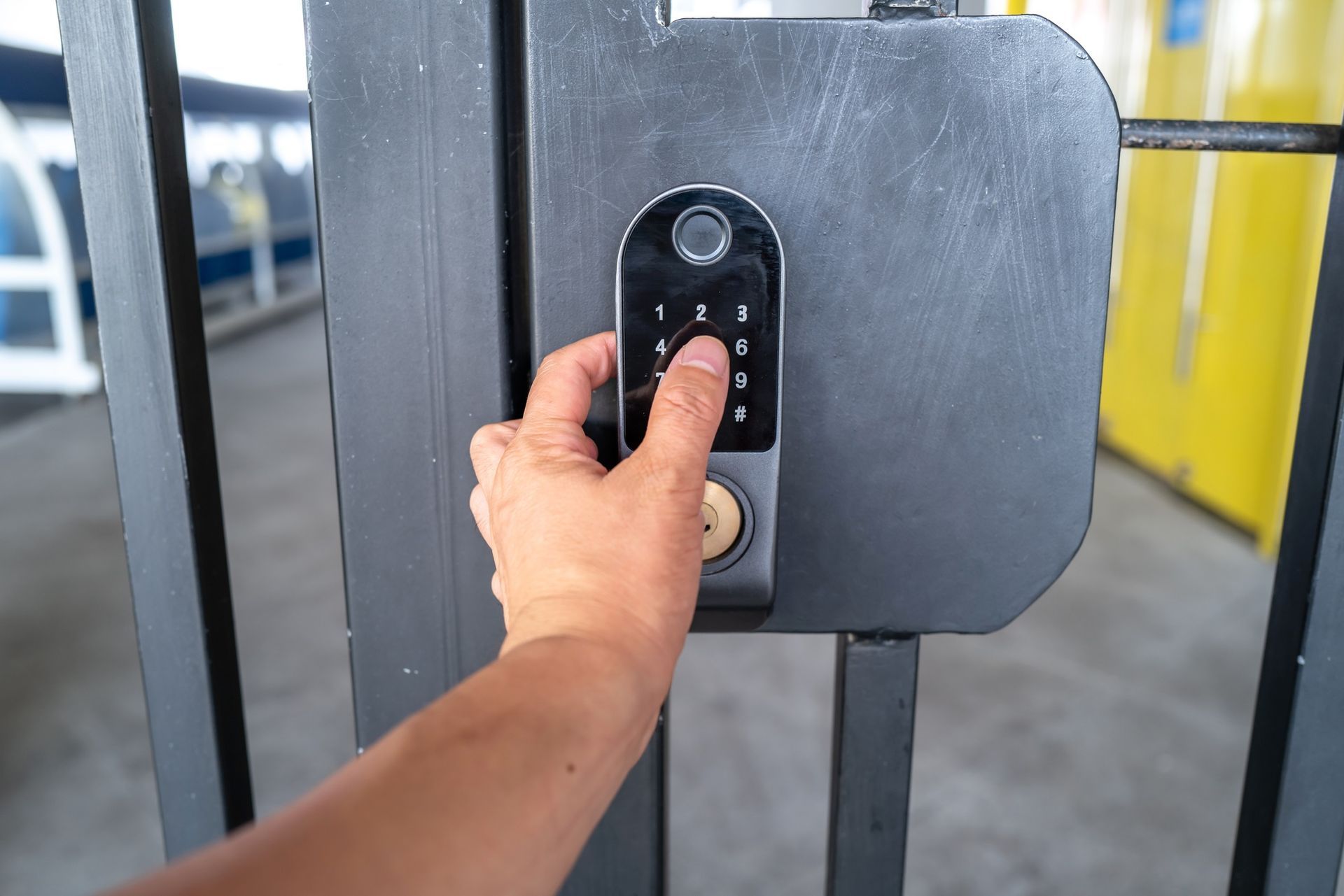 A person is using a keypad to lock a gate. A person is using a keypad to lock a gate.