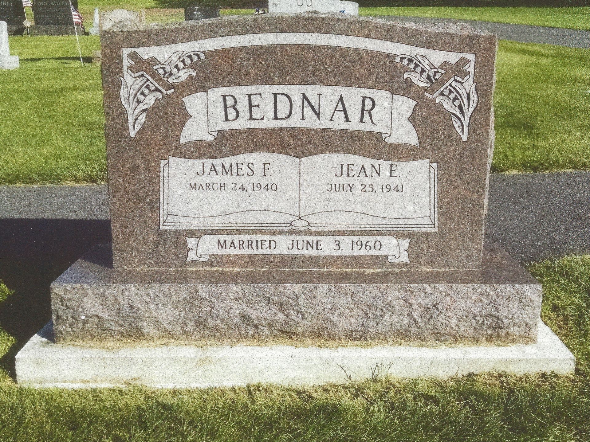 Brown granite memorial headstone with the name BEDNAR in a cemetery.