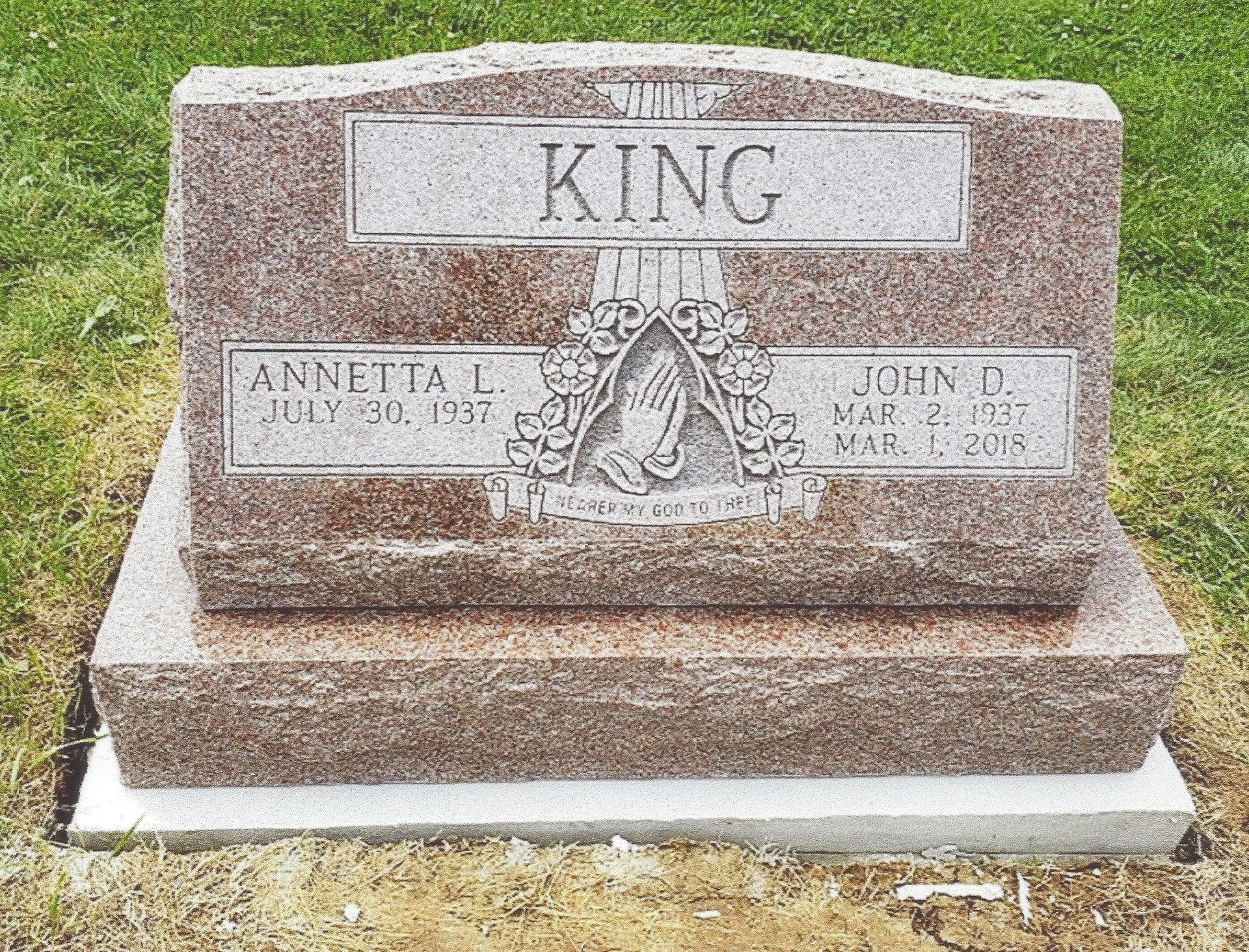 King family gravestone with two names and dates engraved on a granite marker outdoors
