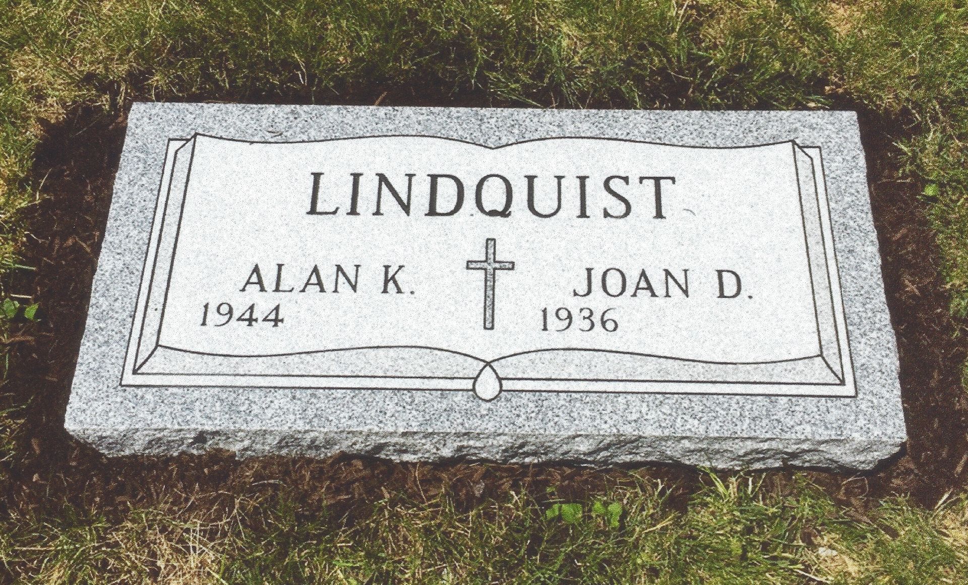 Gravestone for LINDQUIST with names Alan K. and Joan D., engraved cross, set in grass.