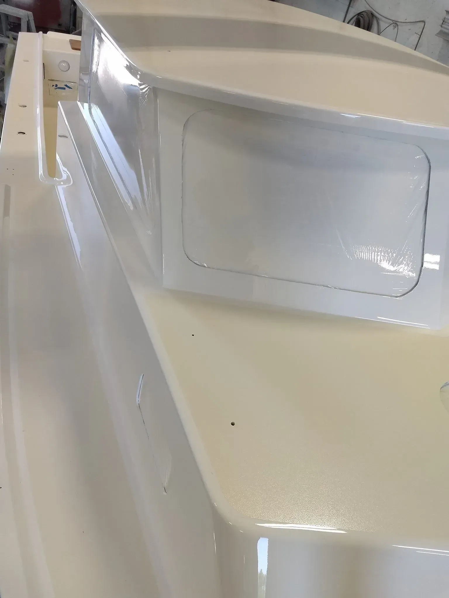 A white boat is being built in a factory