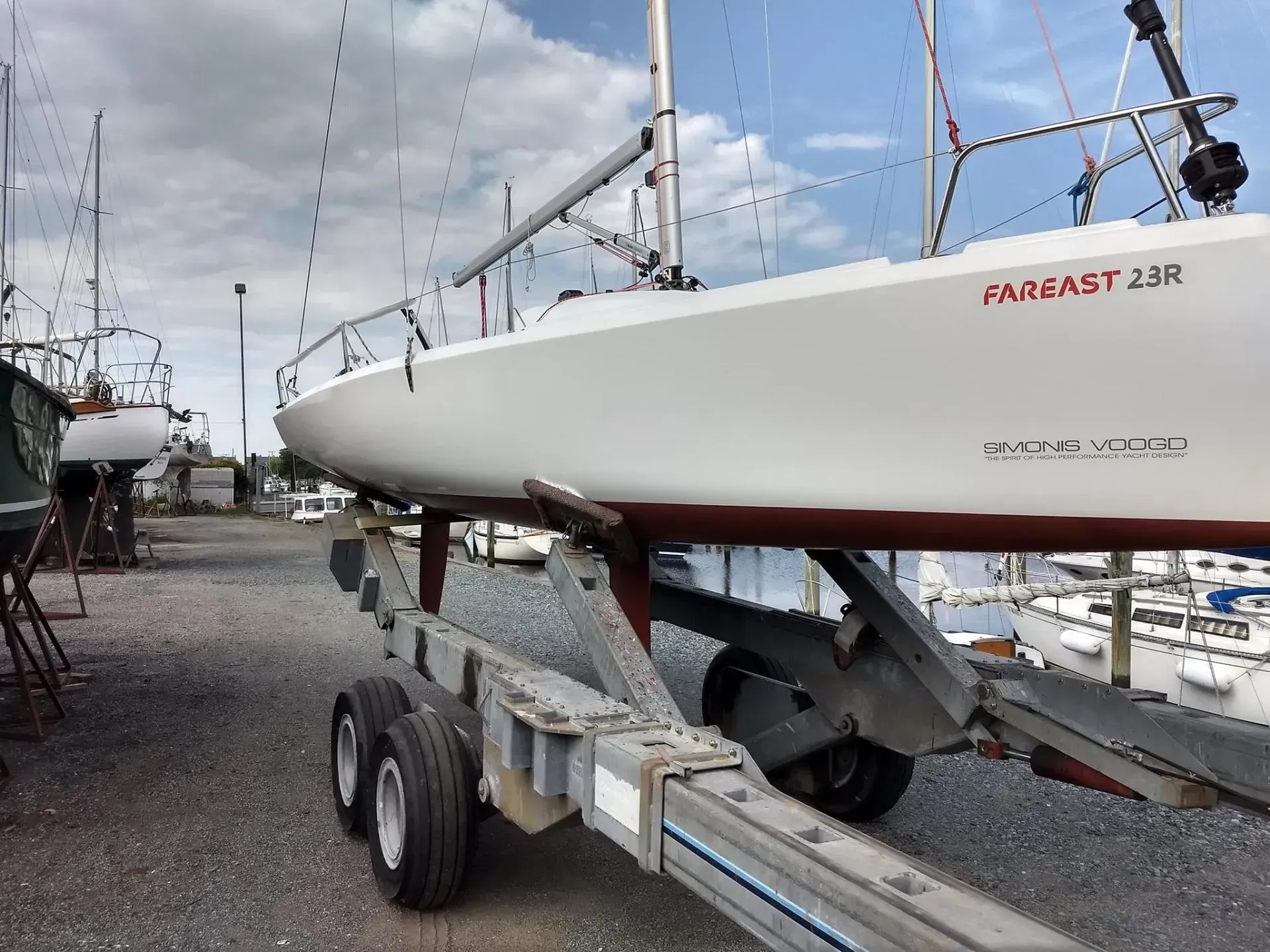 A sailboat is on a trailer in a marina.