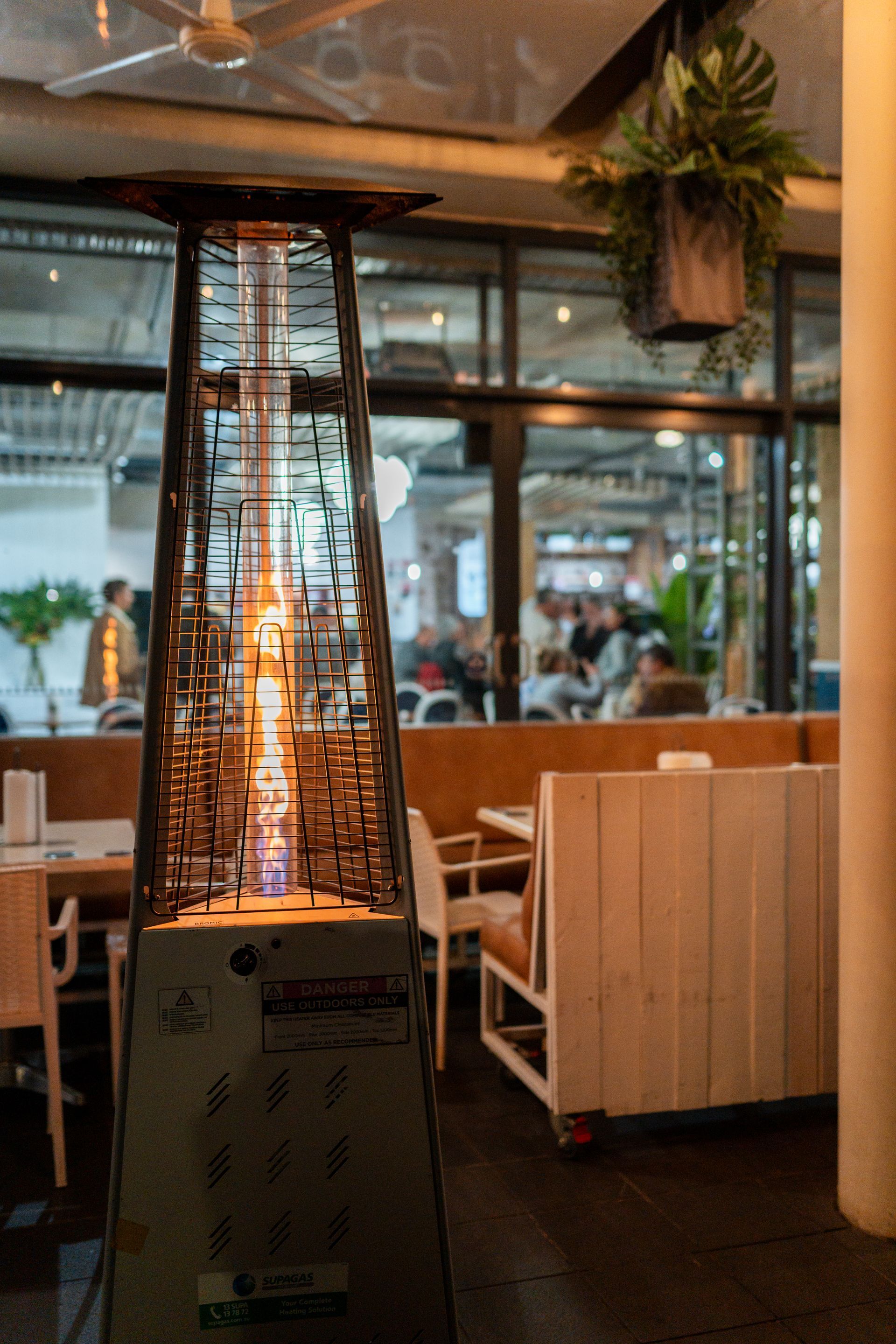 A Patio Heater Is Sitting in The Middle of A Restaurant — Chop 'n Chill in Port Macquarie, NSW