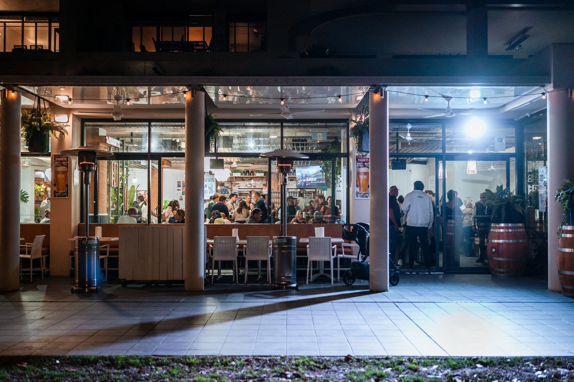 A Group of People Are Standing Outside of A Restaurant at Night — Chop 'n Chill in Port Macquarie, NSW