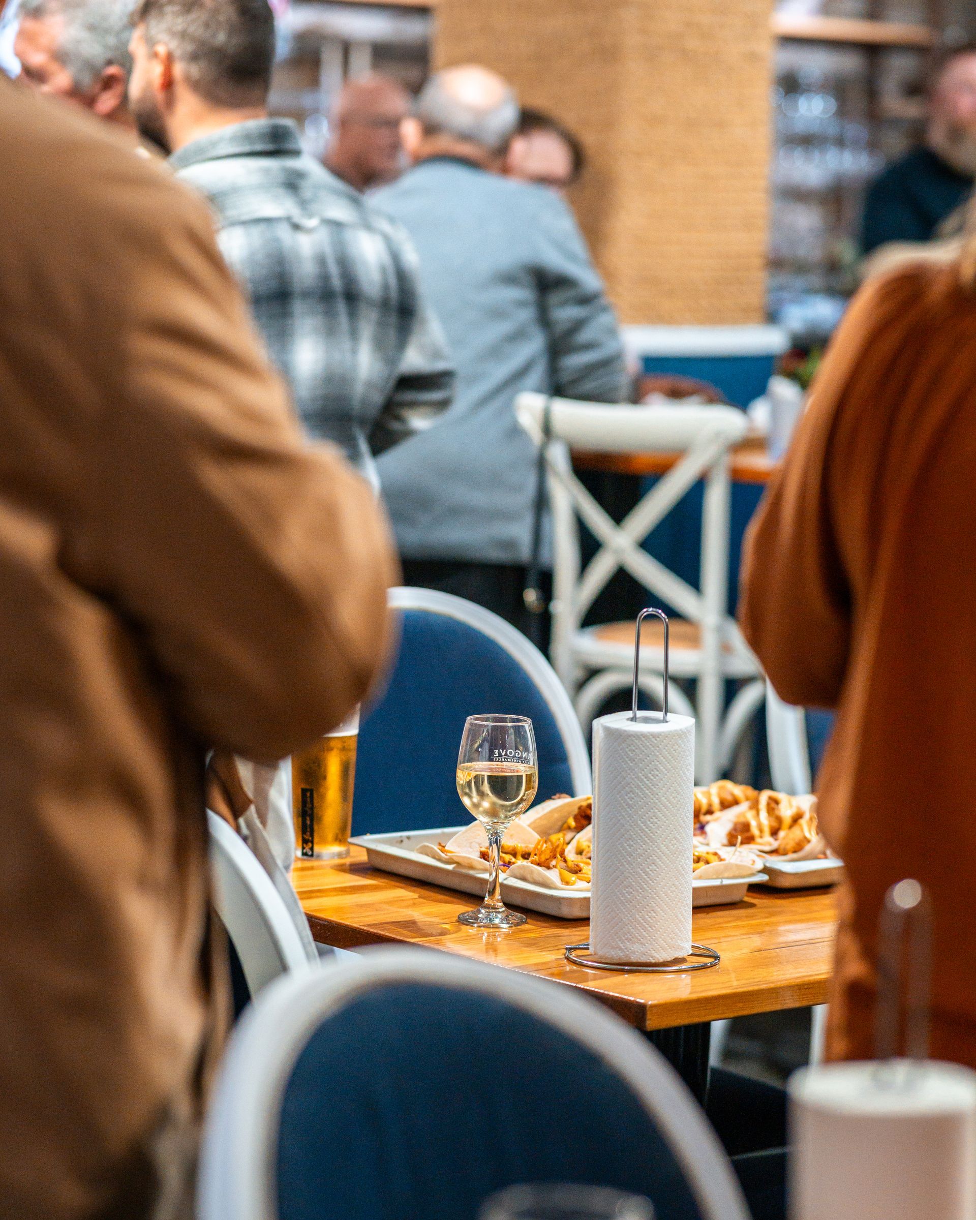 A Group of People Are Sitting at Tables in A Restaurant — Chop 'n Chill in Port Macquarie, NSW