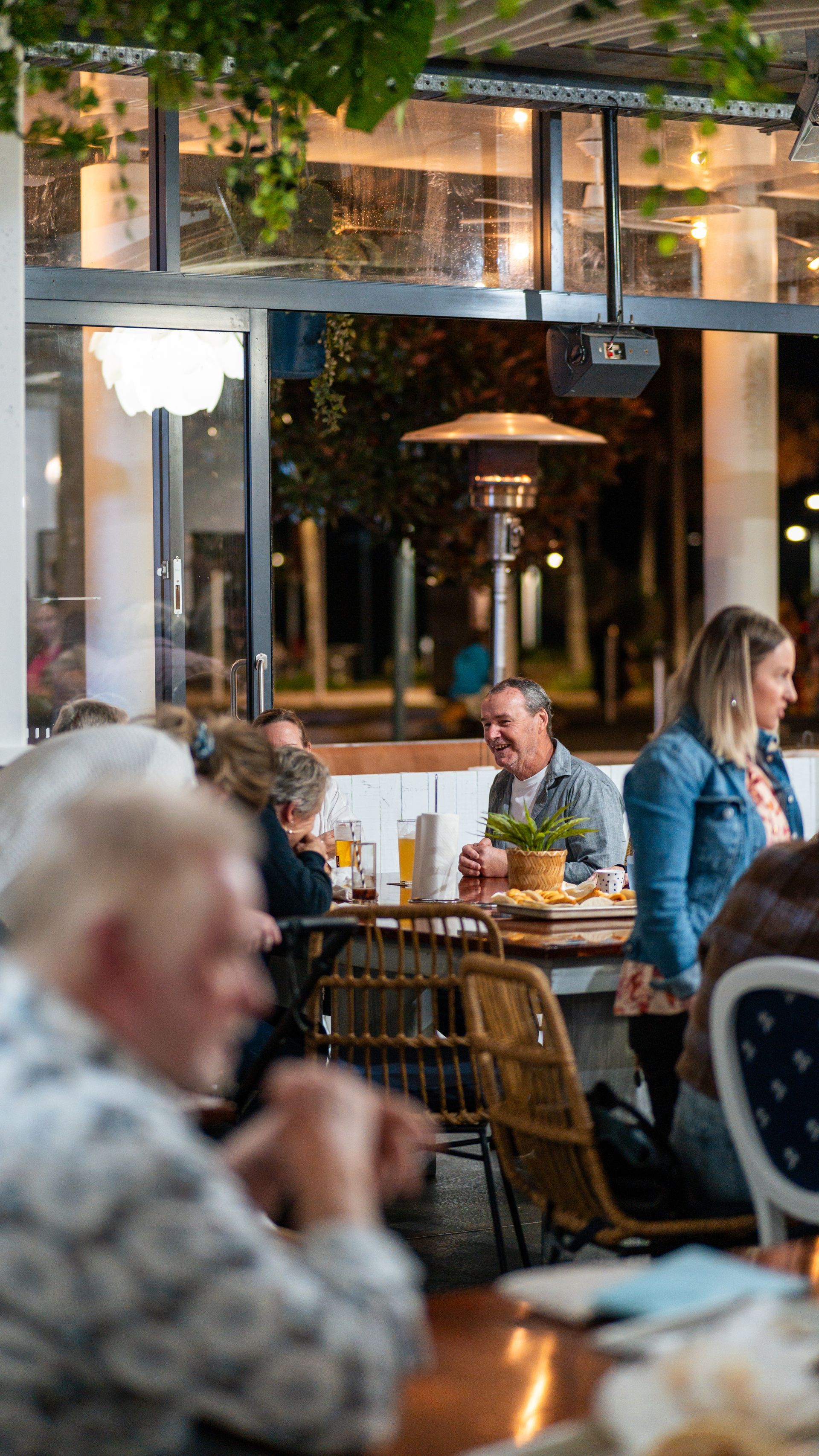 A Group of People Are Sitting at Tables in A Restaurant — Chop 'n Chill in Port Macquarie, NSW