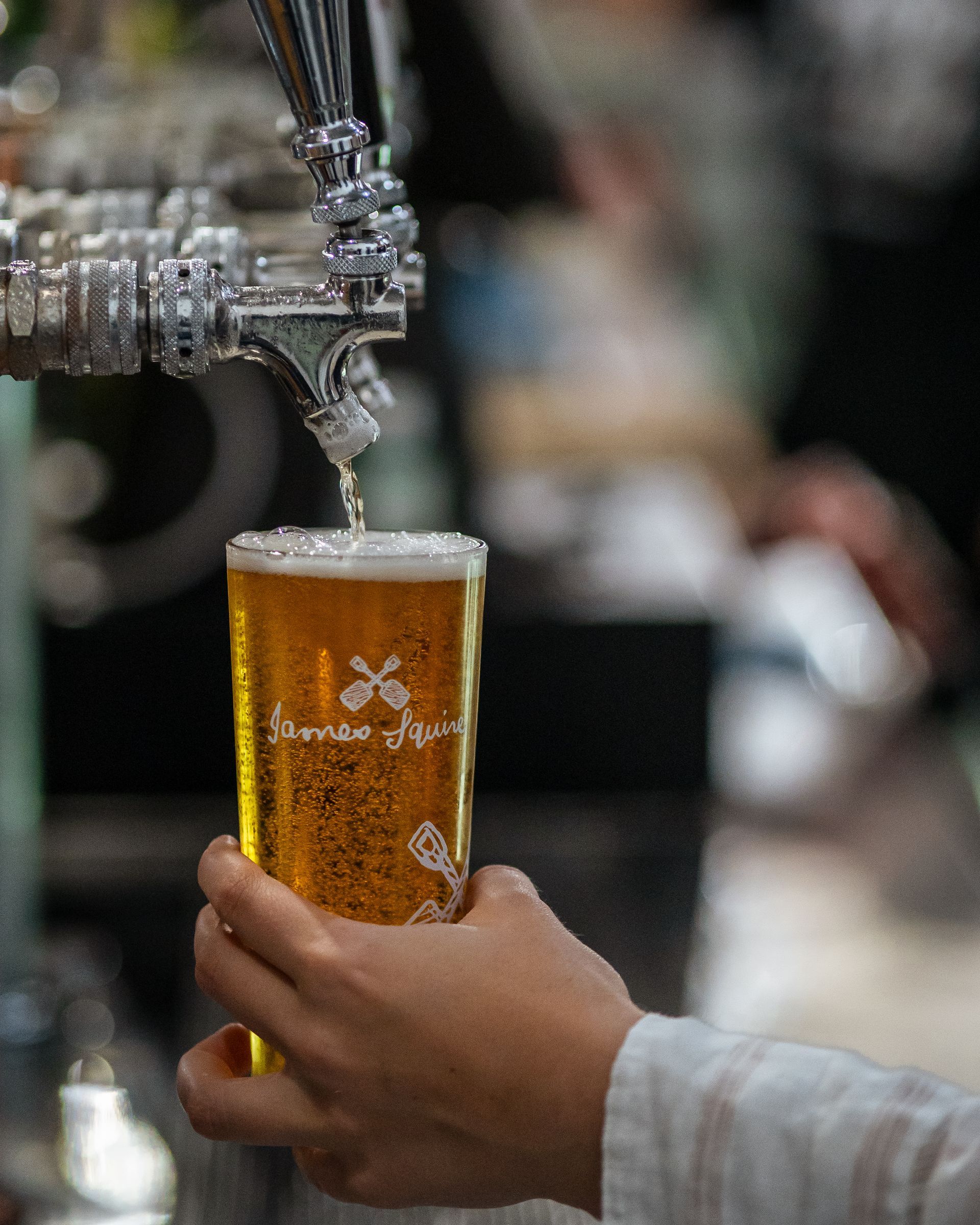 A Person Is Holding a Glass of Beer that Is Being Poured from A Tap — Chop 'n Chill in Port Macquarie, NSW