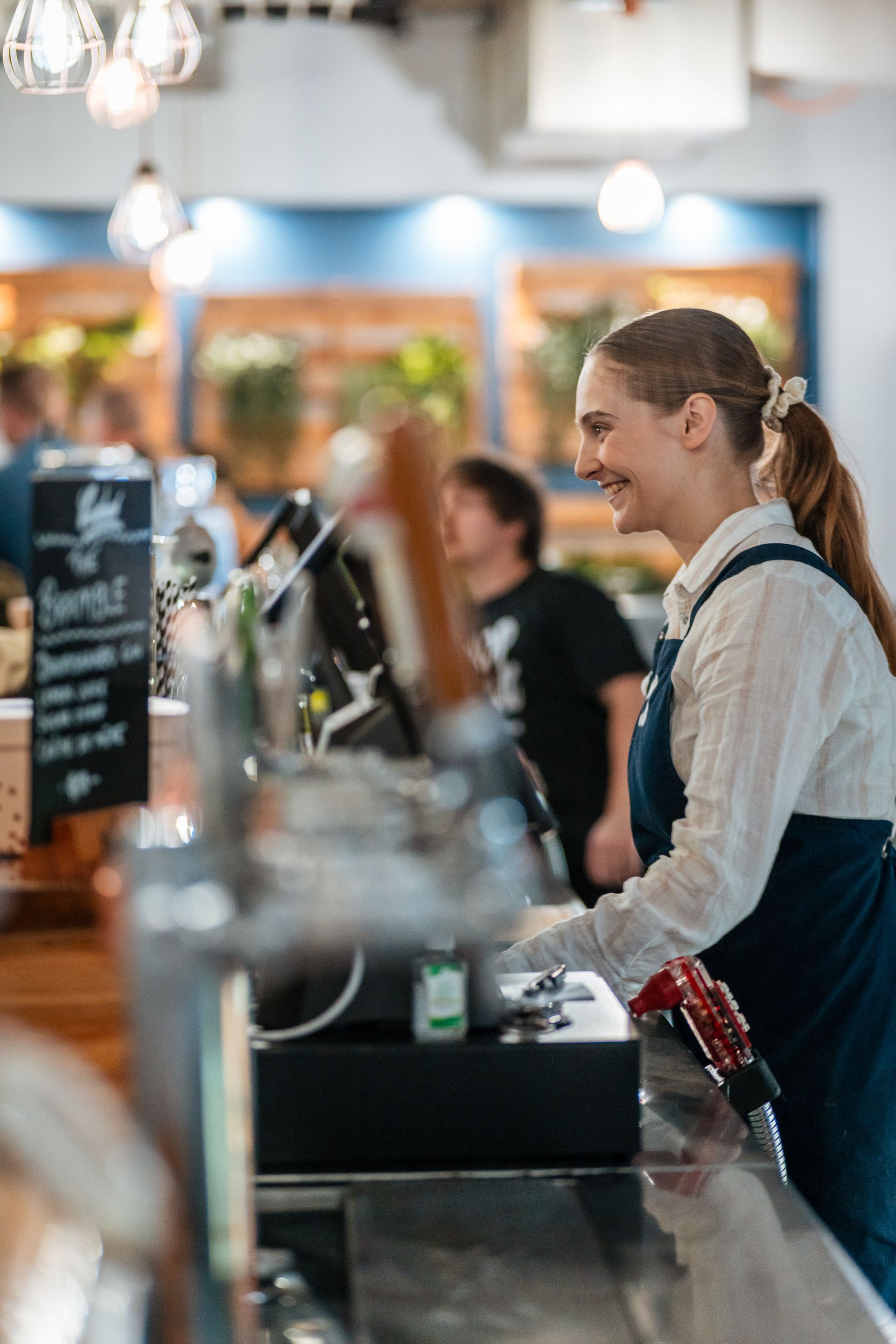 A Woman Is Standing at A Counter in A Restaurant — Chop 'n Chill in Port Macquarie, NSW