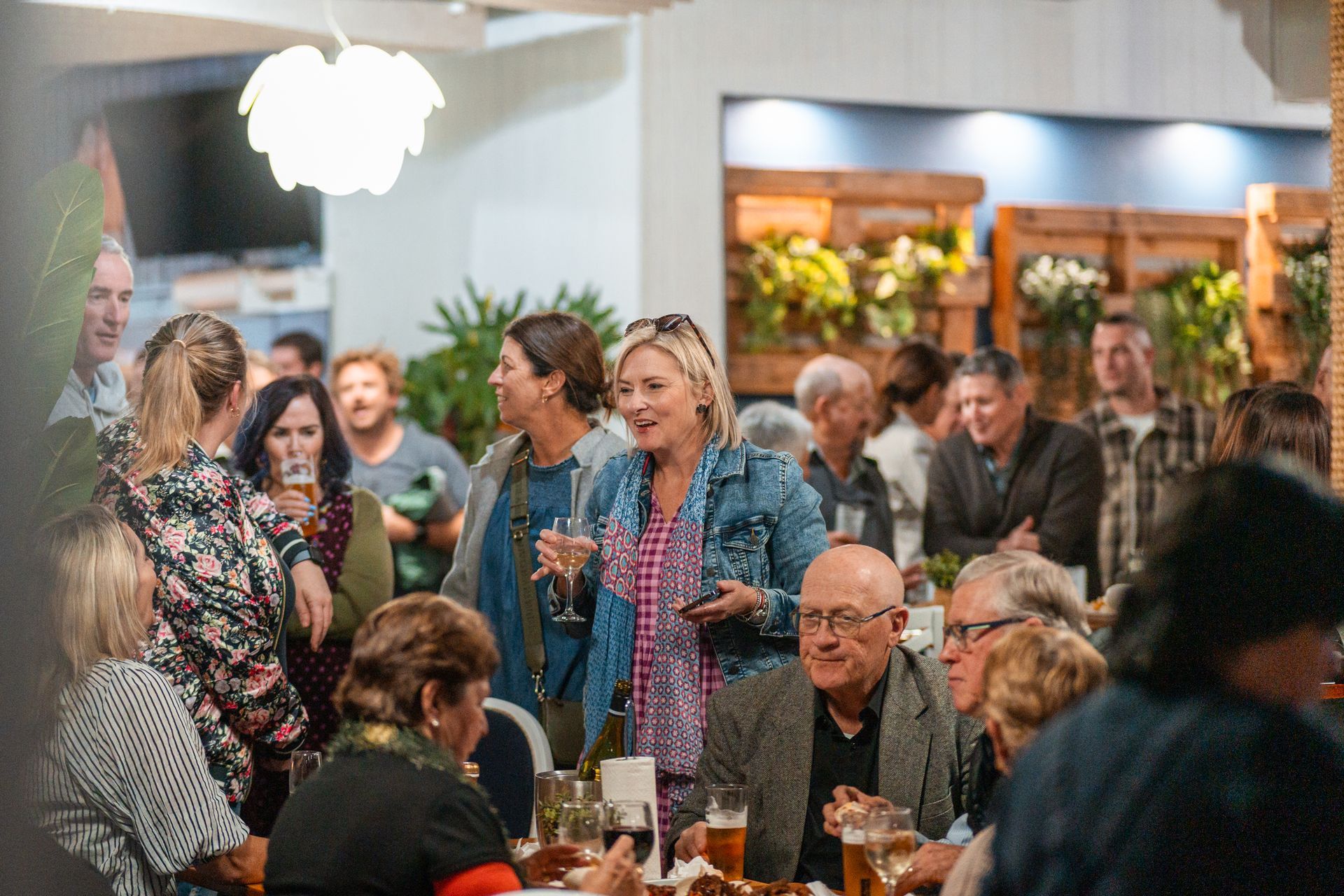 A Group of People Are Sitting at Tables in A Restaurant — Chop 'n Chill in Port Macquarie, NSW