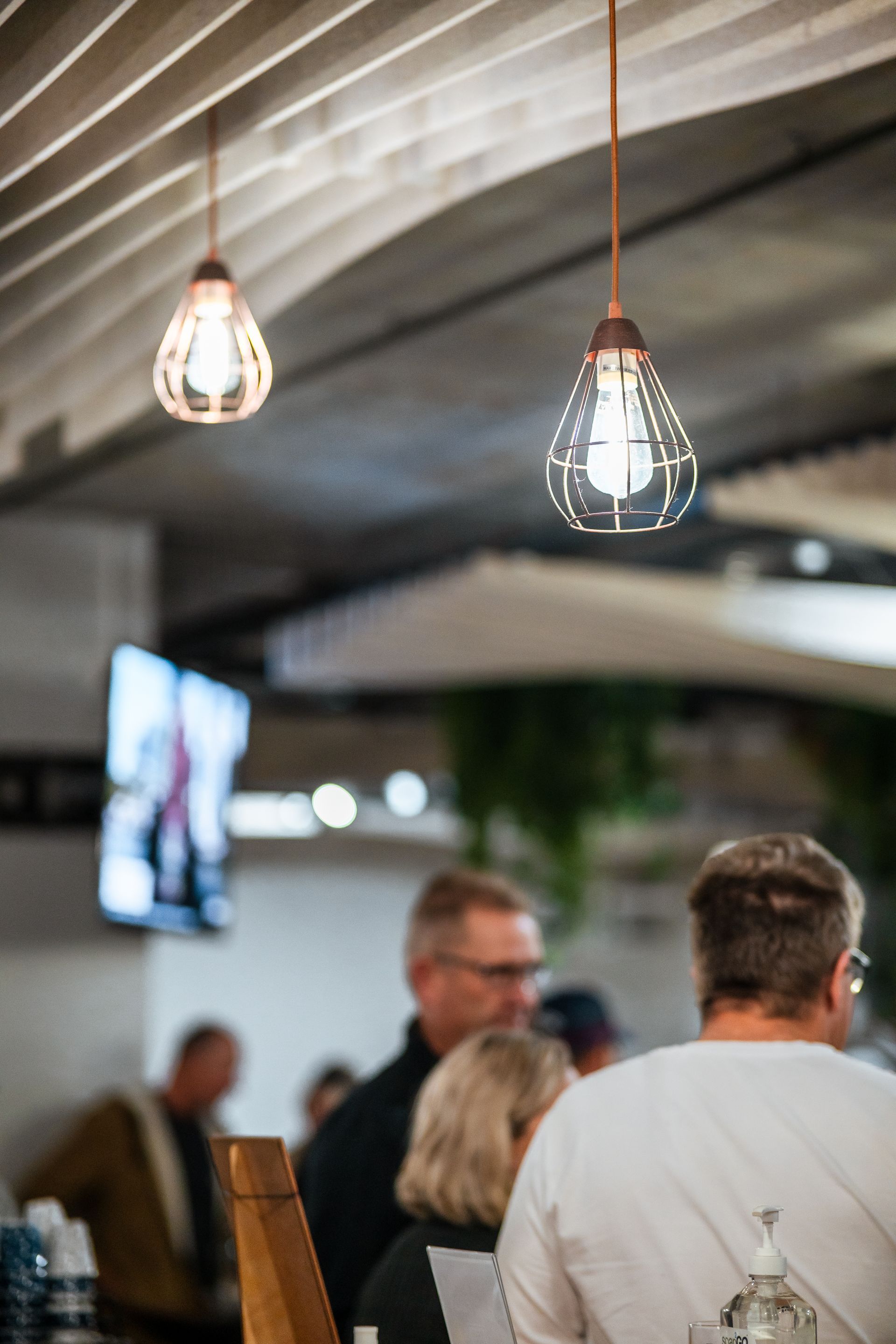 A Group of People Are Sitting at A Table in A Restaurant — Chop 'n Chill in Port Macquarie, NSW
