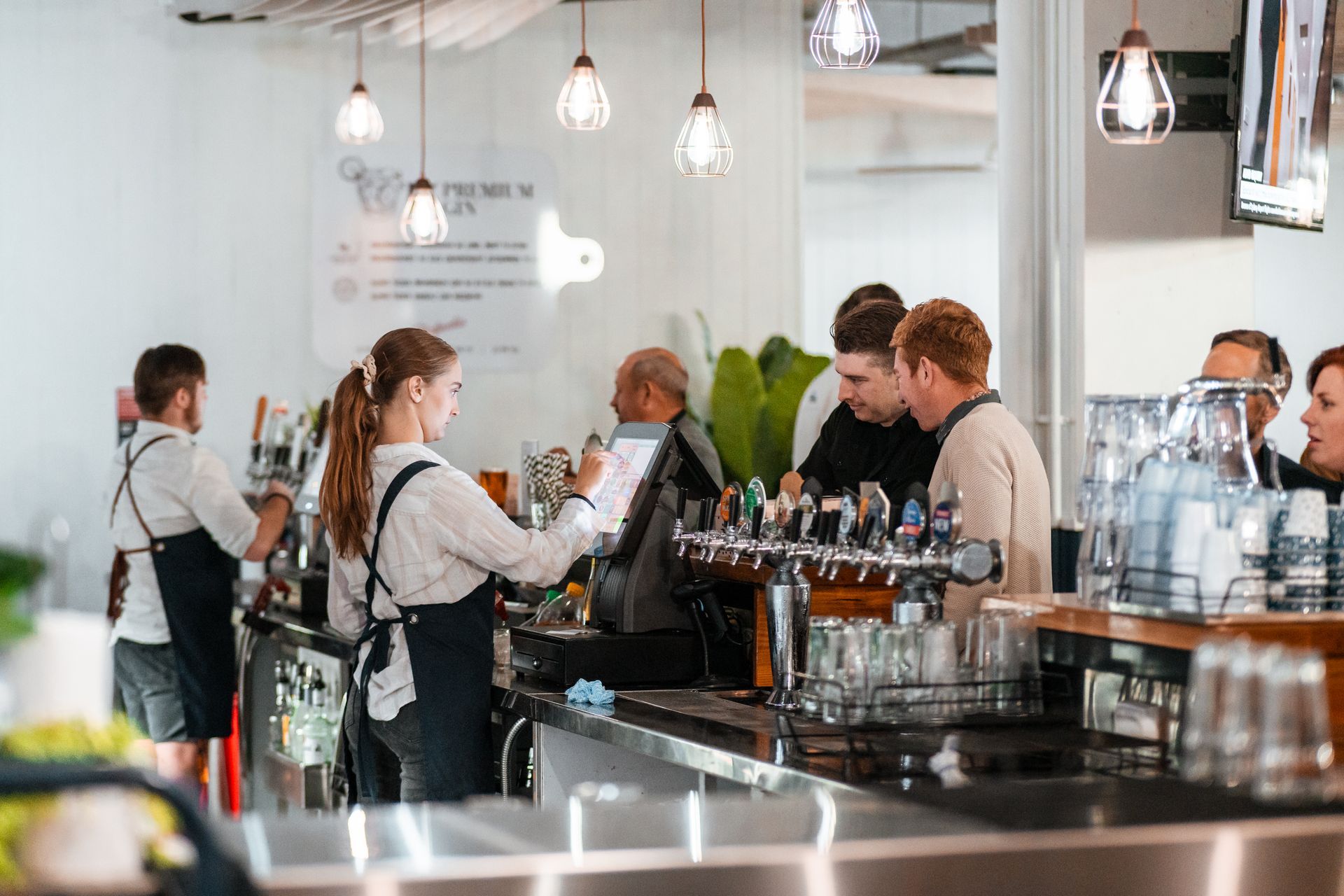 A Group of People Are Standing at A Bar in A Restaurant — Chop 'n Chill in Port Macquarie, NSW