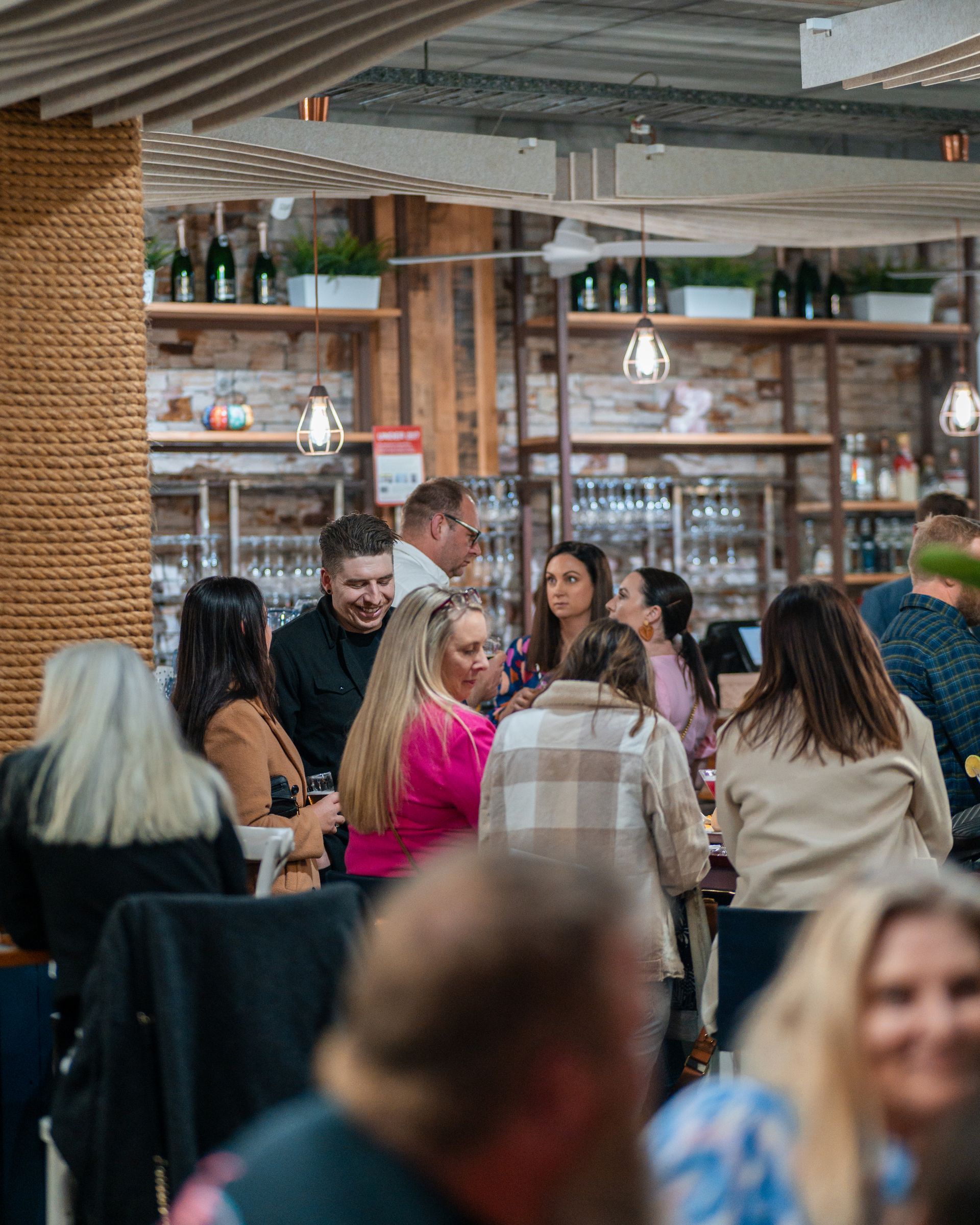 A Group of People Are Sitting at Tables in A Restaurant — Chop 'n Chill in Port Macquarie, NSW