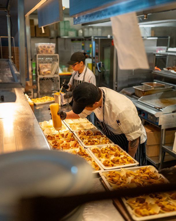 Two Chefs Are Preparing Food in A Restaurant Kitchen — Chop 'n Chill in Port Macquarie, NSW