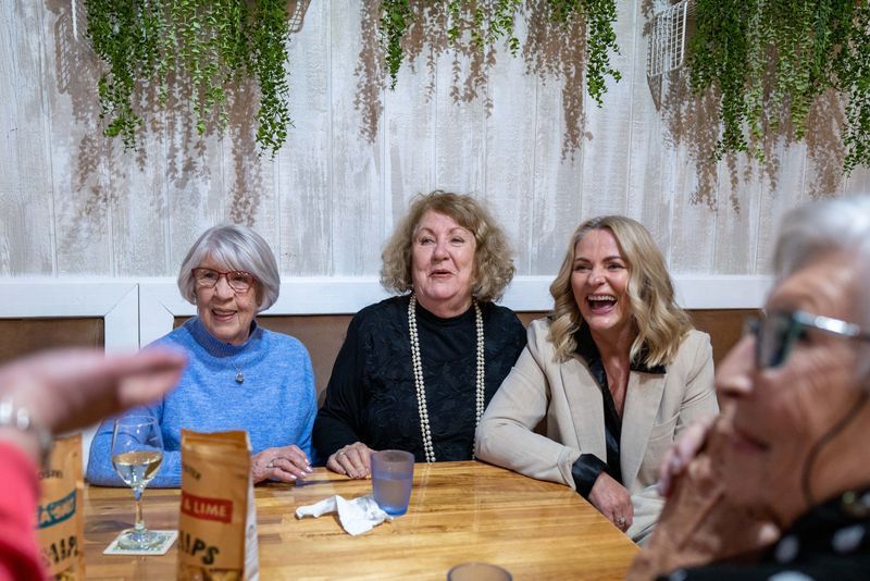 A Group of Older Women Are Sitting at A Table Laughing — Chop 'n Chill in Port Macquarie, NSW