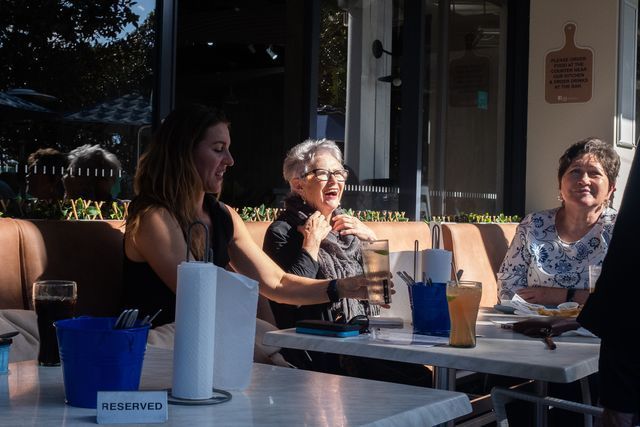 A Group of People Are Sitting at Tables Outside of A Restaurant — Chop 'n Chill in Port Macquarie, NSW