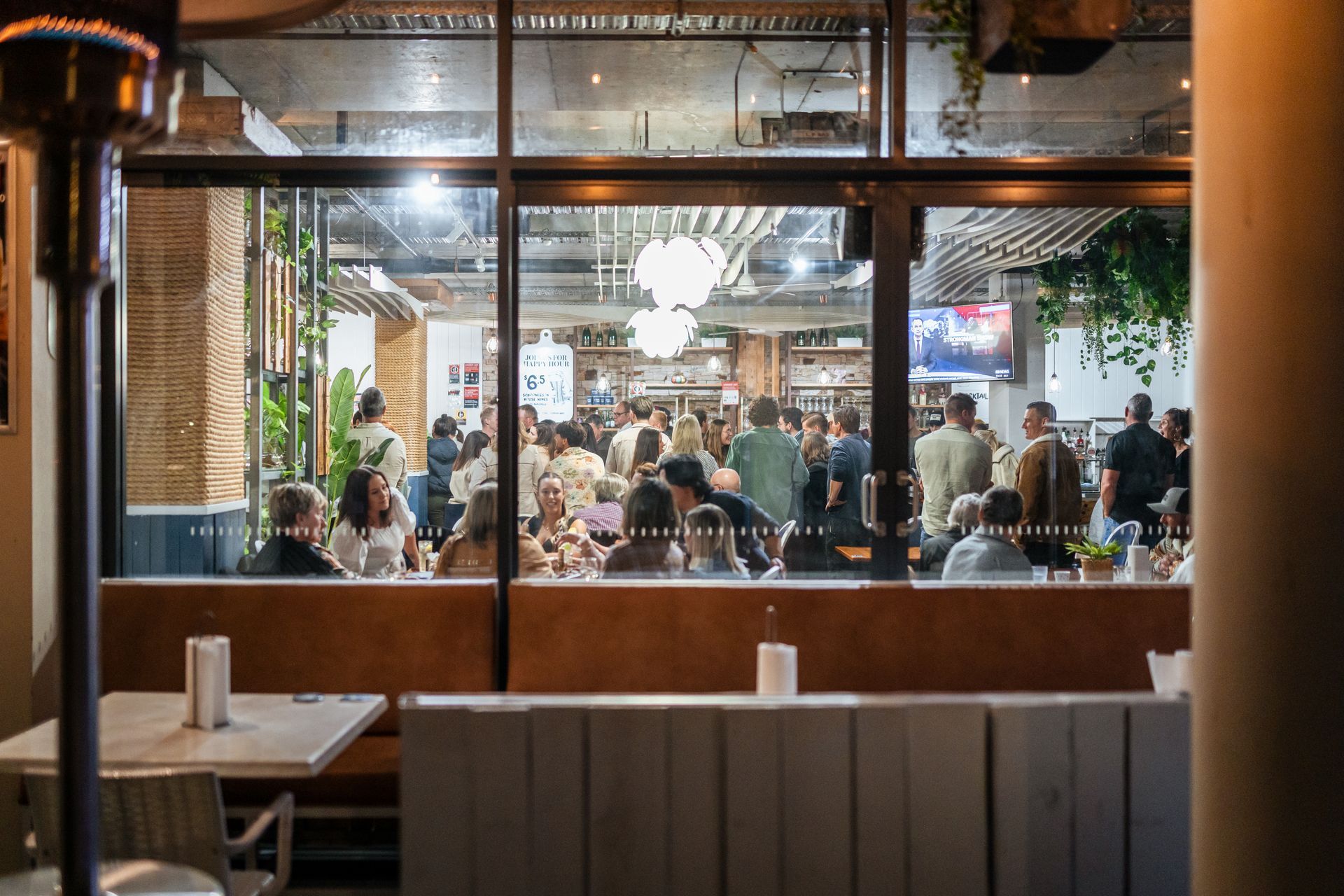 A Group of People Are Sitting at Tables in A Restaurant — Chop 'n Chill in Port Macquarie, NSW