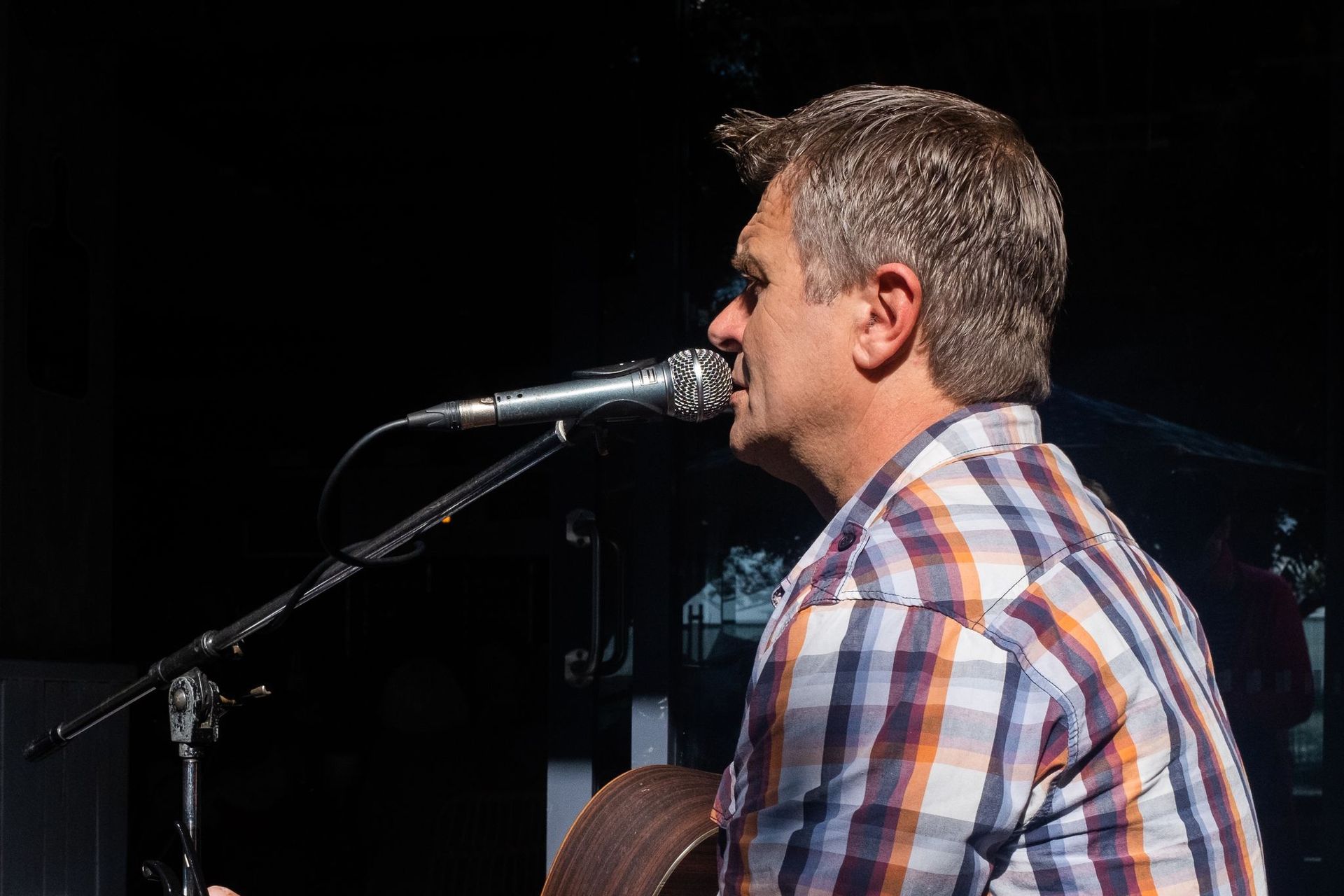 A Man Is Singing Into a Microphone While Holding a Guitar — Chop 'n Chill in Port Macquarie, NSW