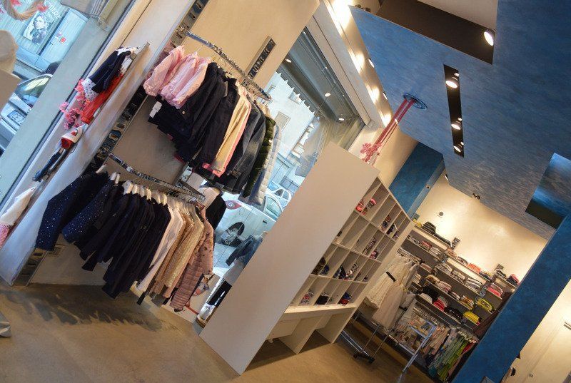 Un negozio con vestiti appesi su scaffali e scaffali