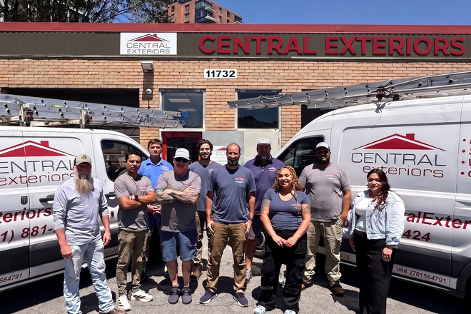 Central Exteriors crew standing in front of company vans and storefront sign
